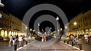 France, Nice - June, 2019: City square with tram tracks and people walking at night. Action. Beautiful old town with