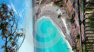 France, Nice, Top view of the famous English promenade with beach on azure sea at sunny day, a sunbathing people in the