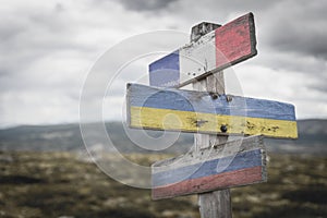 france ukraine russia flag on wooden signpost outdoors in nature.