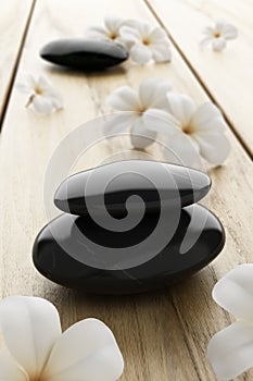Frangipani flower and black stone, zen spa on wood