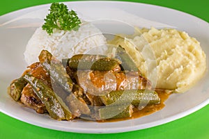 Frango com quiabo. Brazilian food. A chicken meal with okra served with rice and mashed potatoes photo