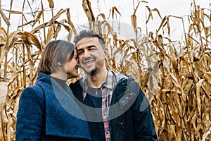 A frank moment of tenderness during a couple's walk in a cornfield in the fall. A woman presses her forehead against
