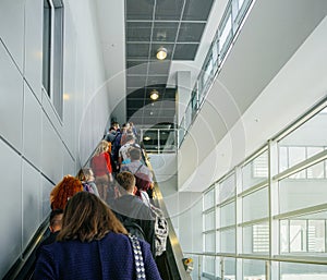 Passengers commuting on the escalator in modern airport terminal