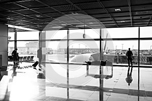 Tourist passengers with suitcase, luggage in lounge hall. People wait for for flight in airport at big window glass