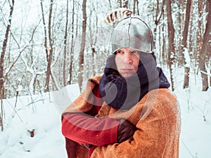 Frankish warrior in historical costume with helmet in winter forest