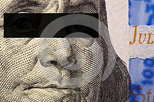 Franklin`s face close-up with a black stripe of censorship on his eyes on a fragment of a 100 dollar bill of the new sample