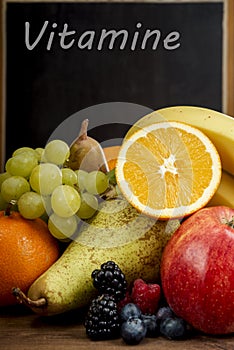 Frash Fruit, Orange, apple, banana, pear, grapes against blackboard