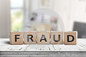 Fraud sign made of wooden blocks on a white desk