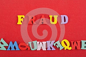 FRAUD word on red background composed from colorful abc alphabet block wooden letters, copy space for ad text. Learning english