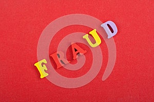 FRAUD word on red background composed from colorful abc alphabet block wooden letters, copy space for ad text. Learning english