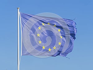 Frayed European Union EU flag is fluttered by wind