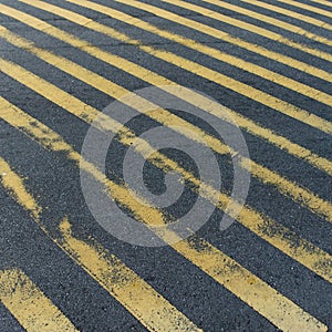 Frayed pedestrian crossing stripes on asphalt