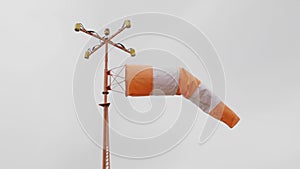 Frayed windsock in moderate wind against blue sky