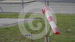 Frayed windsock in moderate wind against blue sky