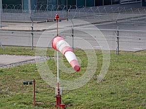 Frayed windsock in moderate wind against blue sky