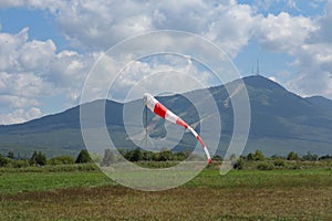 Frayed windsock in moderate wind on the background of mountains