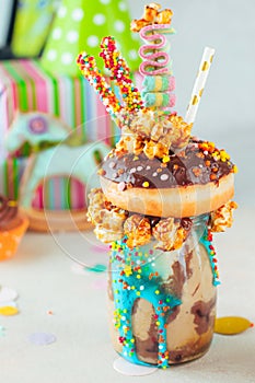 Freak shake with chocolate donut on party background