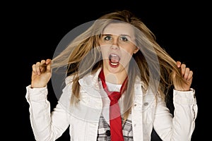 Freaking out young female pulling hair black background