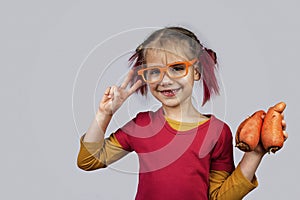 Freakish kid holds misshapen wrong color fruits and vegetables, waste food concept