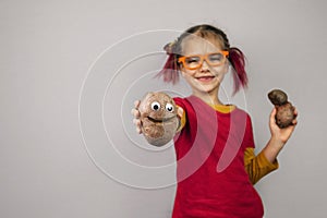 Freakish kid holds misshapen wrong color fruits and vegetables, waste food concept