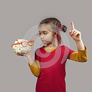 Freakish kid holds misshapen wrong color fruits and vegetables, waste food concept