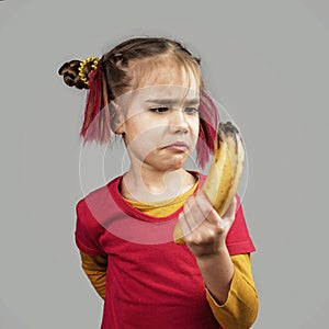 Freakish kid holds misshapen wrong color fruits and vegetables, waste food concept