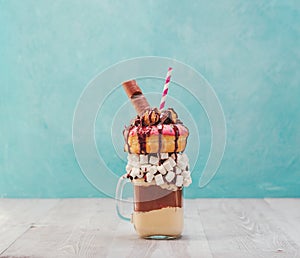 Freakshake with donuts on gray wooden background