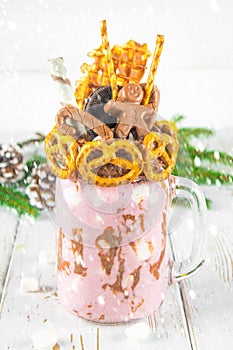 Freakshake from pink smoothie, cream. Monstershake with a chocolate man, cane, pretzels, biscuits, waffles and marshmallow. Extrem