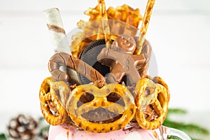 Freakshake from pink smoothie, cream. Monstershake with a chocolate man, cane, pretzels, biscuits, waffles and marshmallow. Extrem