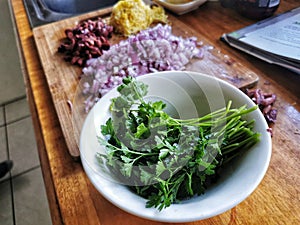 Freash parsley, chopped onions and olives on a wooden kitchen bench photo