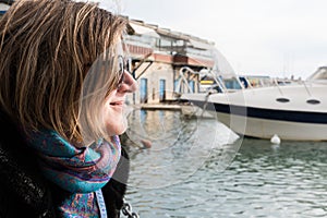 Freattyda, Athens - Greece - Happy thirty year old woman with sunglasses smiling on vacation with a yacht on the background