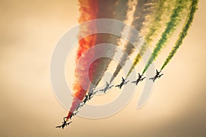 Frecce Tricolori alona : italian aerobatic Team performing a low pass with italian flag colors smokes in sunset