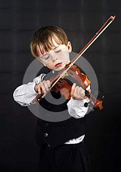 Freckled red-hair boy playing violin.