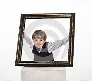 Freckled red-hair little boy with big picture frame.