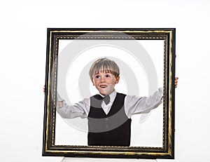 Freckled red-hair little boy with big picture frame.