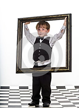 Freckled red-hair little boy with big picture frame.