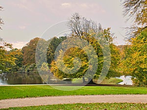 Frederiksborg Castle Park in autumn with mighty deciduous trees on the garden meadows