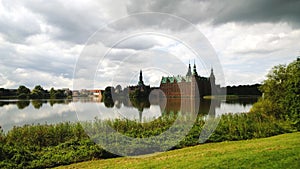 Frederiksborg castle in the suburbs of Copenhagen HillerÃ¸d. In the frame the castle, the pond next to it