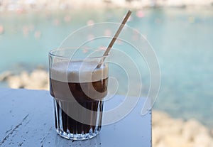 Fredo espresso iced coffee on the beach. Refreshment outdoor. Black coffee photo