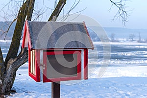 Free book sharing mini house near the river in cold winter morning