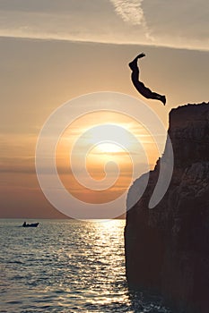 Free boy flying in the sky by jumping from the cliff