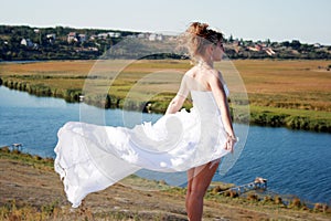 Free bride standing above the river
