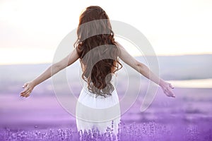 Free brunette woman with open arms enjoying sunset in lavender f