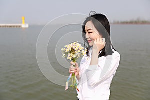 Free careless causual beauty enjoy good time next to a lake ocean river beach hold a bunch of flower