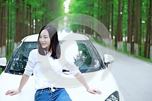 Free carelss happy woman enjoy cozy comfortable life drive a white car on a road in forest