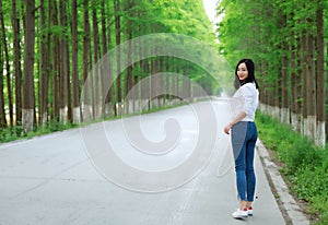 Free carelss woman walk on road in forest outdoor enjoy fresh air