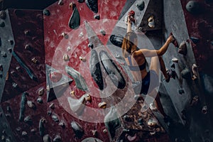 Free climber female bouldering indoors.