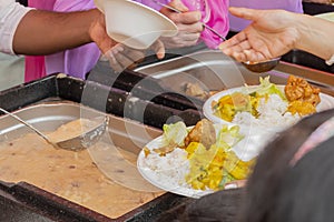 Free distribution of food and treats at a Hindu festival, vegetarian meals for passersby, feeding lit food to people.