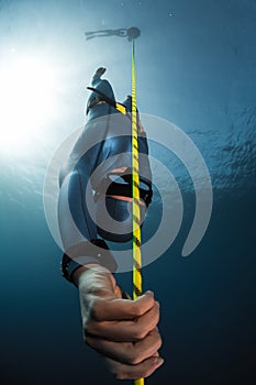 Free diver descending along the rope