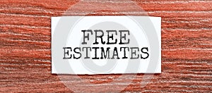 FREE ESTIMATES text on the piece of paper on the red wood background